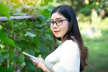 young small business owner women looking and checking on organic plantation or farm.