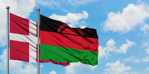 Denmark and Malawi flag waving in the wind against white cloudy blue sky together. Diplomacy concept, international relations.