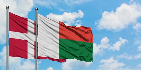 Denmark and Madagascar flag waving in the wind against white cloudy blue sky together. Diplomacy concept, international relations.