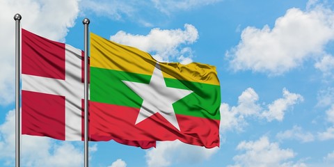 Denmark and Myanmar flag waving in the wind against white cloudy blue sky together. Diplomacy concept, international relations.