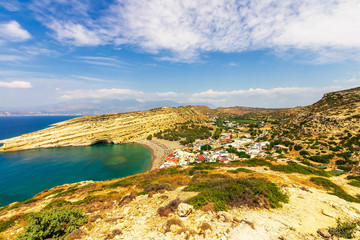 Fototapeta na wymiar amazing view from a mountain to a nice gulf , beach , rocks and deep azure sea and high mountains with clouds and blue sky on the background