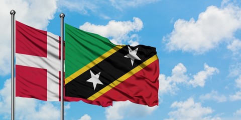 Denmark and Saint Kitts And Nevis flag waving in the wind against white cloudy blue sky together. Diplomacy concept, international relations.