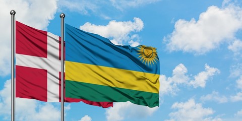 Denmark and Rwanda flag waving in the wind against white cloudy blue sky together. Diplomacy concept, international relations.