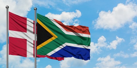 Denmark and South Africa flag waving in the wind against white cloudy blue sky together. Diplomacy concept, international relations.