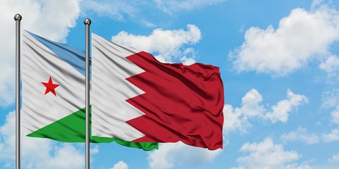 Djibouti and Bahrain flag waving in the wind against white cloudy blue sky together. Diplomacy concept, international relations.