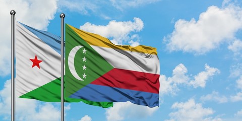 Djibouti and Comoros flag waving in the wind against white cloudy blue sky together. Diplomacy concept, international relations.
