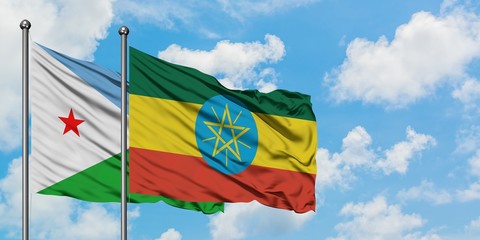 Djibouti and Ethiopia flag waving in the wind against white cloudy blue sky together. Diplomacy concept, international relations.