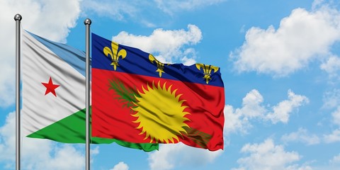 Djibouti and Guadeloupe flag waving in the wind against white cloudy blue sky together. Diplomacy concept, international relations.
