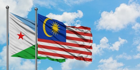 Djibouti and Malaysia flag waving in the wind against white cloudy blue sky together. Diplomacy concept, international relations.