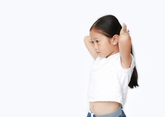 Portrait of little Asian child girl tying her hair by yourself isolated on white background.