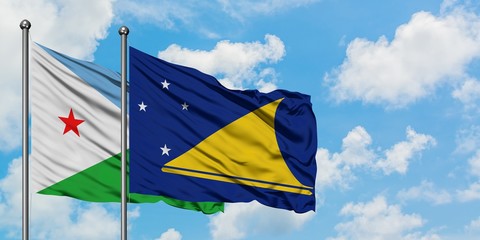 Djibouti and Tokelau flag waving in the wind against white cloudy blue sky together. Diplomacy concept, international relations.