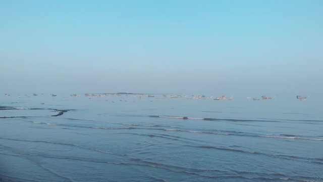 gorai beach black sand blue sky reflecting on wet sand on beach ships on the horizon