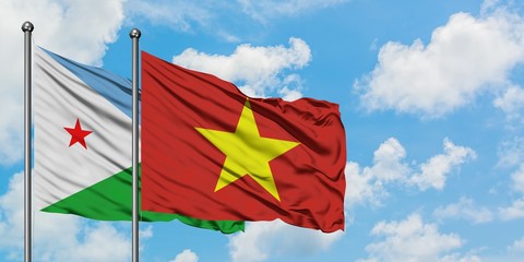 Djibouti and Vietnam flag waving in the wind against white cloudy blue sky together. Diplomacy concept, international relations.