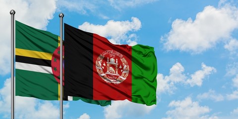 Dominica and Afghanistan flag waving in the wind against white cloudy blue sky together. Diplomacy...