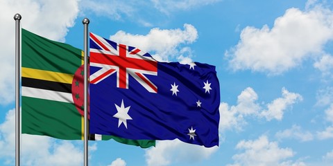 Dominica and Australia flag waving in the wind against white cloudy blue sky together. Diplomacy...