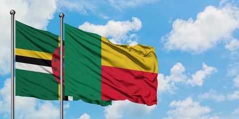 Dominica and Benin flag waving in the wind against white cloudy blue sky together. Diplomacy concept, international relations.