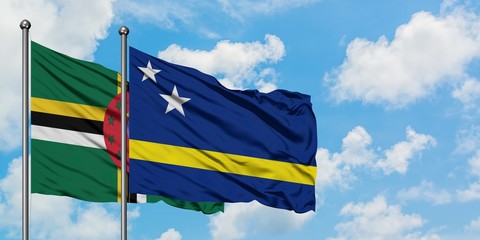 Dominica and Curacao flag waving in the wind against white cloudy blue sky together. Diplomacy concept, international relations.
