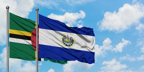 Dominica and El Salvador flag waving in the wind against white cloudy blue sky together. Diplomacy...