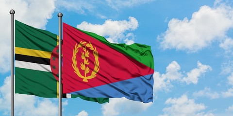 Dominica and Eritrea flag waving in the wind against white cloudy blue sky together. Diplomacy concept, international relations.