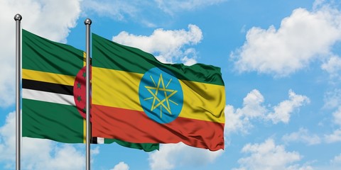 Dominica and Ethiopia flag waving in the wind against white cloudy blue sky together. Diplomacy concept, international relations.
