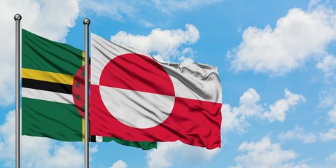 Dominica and Greenland flag waving in the wind against white cloudy blue sky together. Diplomacy concept, international relations.