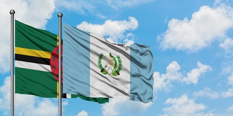 Dominica and Guatemala flag waving in the wind against white cloudy blue sky together. Diplomacy...