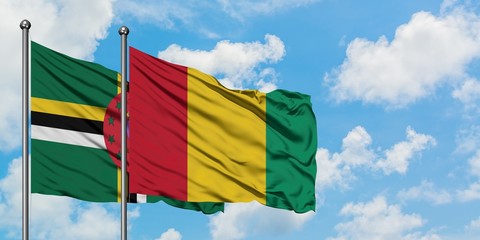 Dominica and Guinea flag waving in the wind against white cloudy blue sky together. Diplomacy concept, international relations.