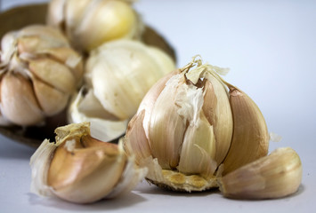 fresh unpeeled garlic on coconut shell isolated on white background