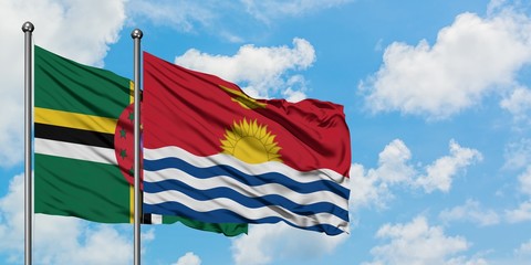 Dominica and Kiribati flag waving in the wind against white cloudy blue sky together. Diplomacy concept, international relations.