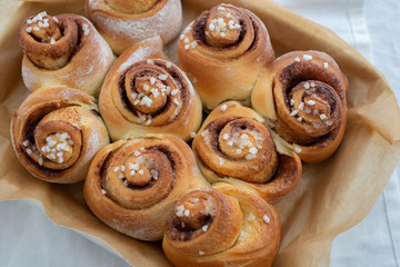 Cinnamon rolls with sugar frosting. With cinnamon sticks and spices, wooden background