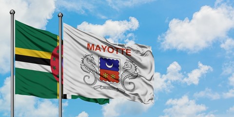 Dominica and Mayotte flag waving in the wind against white cloudy blue sky together. Diplomacy concept, international relations.