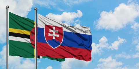 Dominica and Slovakia flag waving in the wind against white cloudy blue sky together. Diplomacy concept, international relations.