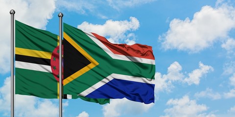 Dominica and South Africa flag waving in the wind against white cloudy blue sky together. Diplomacy concept, international relations.