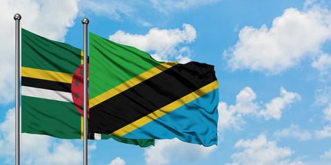 Dominica and Tanzania flag waving in the wind against white cloudy blue sky together. Diplomacy concept, international relations.