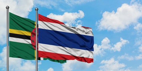 Dominica and Thailand flag waving in the wind against white cloudy blue sky together. Diplomacy concept, international relations.