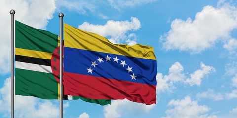 Dominica and Venezuela flag waving in the wind against white cloudy blue sky together. Diplomacy concept, international relations.