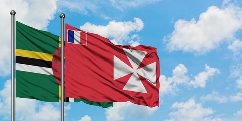Dominica and Wallis And Futuna flag waving in the wind against white cloudy blue sky together. Diplomacy concept, international relations.