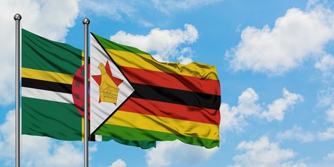 Dominica and Zimbabwe flag waving in the wind against white cloudy blue sky together. Diplomacy concept, international relations.