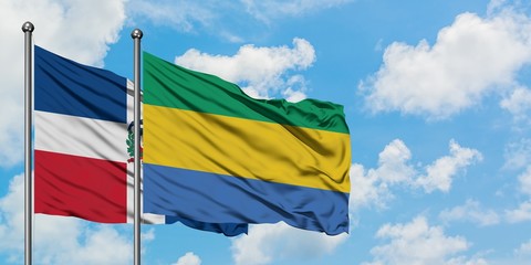 Dominican Republic and Gabon flag waving in the wind against white cloudy blue sky together. Diplomacy concept, international relations.