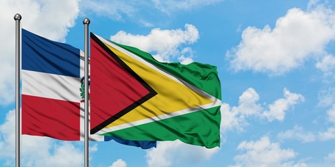Dominican Republic and Guyana flag waving in the wind against white cloudy blue sky together. Diplomacy concept, international relations.