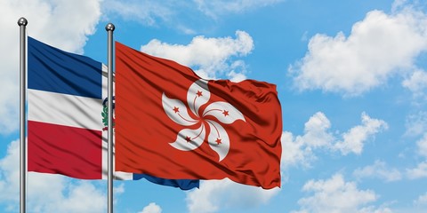 Dominican Republic and Hong Kong flag waving in the wind against white cloudy blue sky together. Diplomacy concept, international relations.
