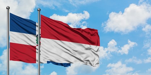 Dominican Republic and Indonesia flag waving in the wind against white cloudy blue sky together. Diplomacy concept, international relations.
