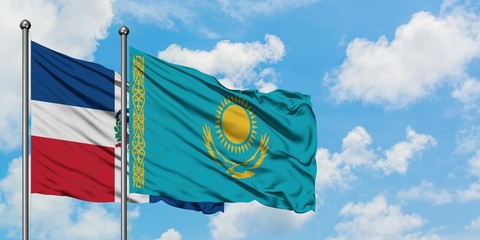 Dominican Republic and Kazakhstan flag waving in the wind against white cloudy blue sky together. Diplomacy concept, international relations.