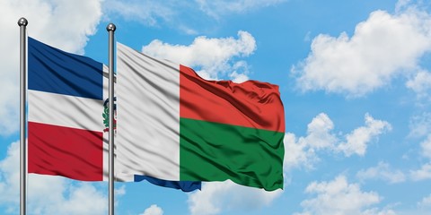 Dominican Republic and Madagascar flag waving in the wind against white cloudy blue sky together. Diplomacy concept, international relations.