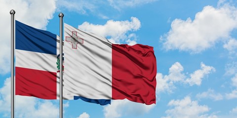 Dominican Republic and Malta flag waving in the wind against white cloudy blue sky together. Diplomacy concept, international relations.