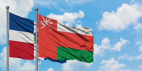 Dominican Republic and Oman flag waving in the wind against white cloudy blue sky together. Diplomacy concept, international relations.