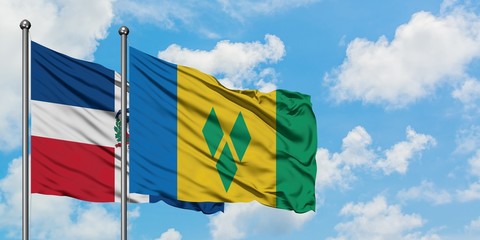 Dominican Republic and Saint Vincent And The Grenadines flag waving in the wind against white cloudy blue sky together. Diplomacy concept, international relations.
