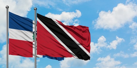 Dominican Republic and Trinidad And Tobago flag waving in the wind against white cloudy blue sky together. Diplomacy concept, international relations.
