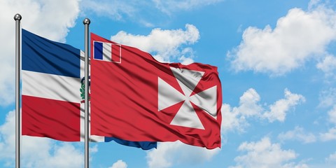 Dominican Republic and Wallis And Futuna flag waving in the wind against white cloudy blue sky together. Diplomacy concept, international relations.