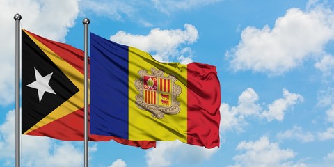 East Timor and Andorra flag waving in the wind against white cloudy blue sky together. Diplomacy concept, international relations.